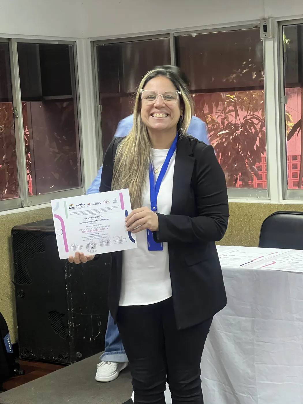 Una persona egresada del diplomado sonríe con su certificado