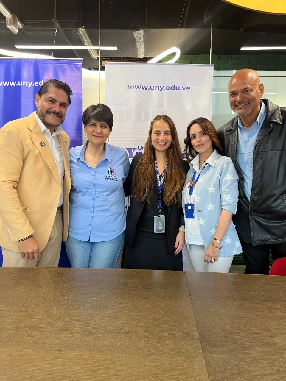 Equipos de la Fundación y de la Universidad Yacambú posan juntos frente a los pendones de la universidad